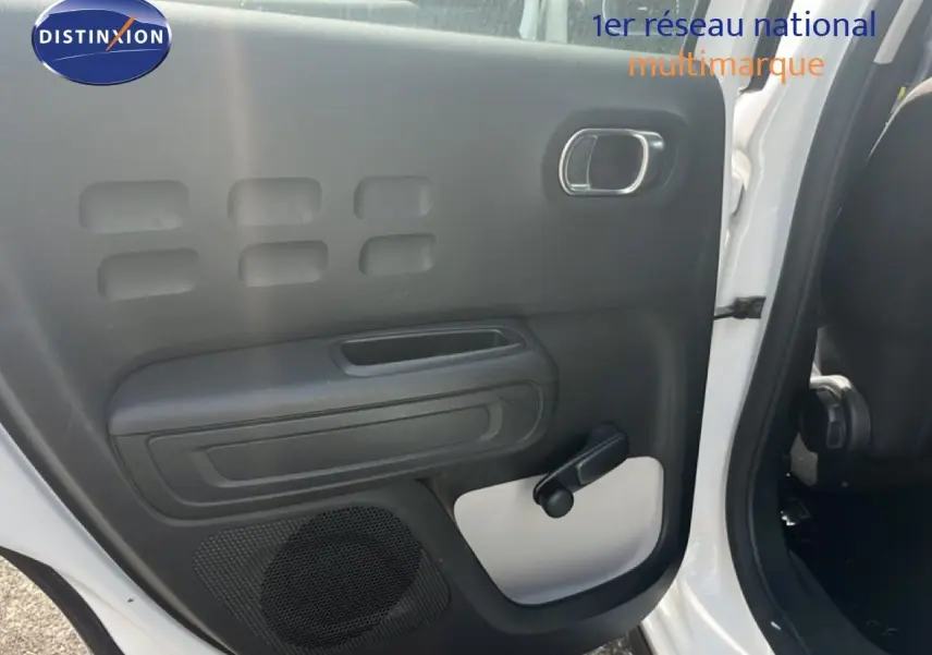 Vue intérieure côté gauche de la porte arrière blanche d'une Citroën C3 2018 avec poignée manuelle et haut-parleur intégré.