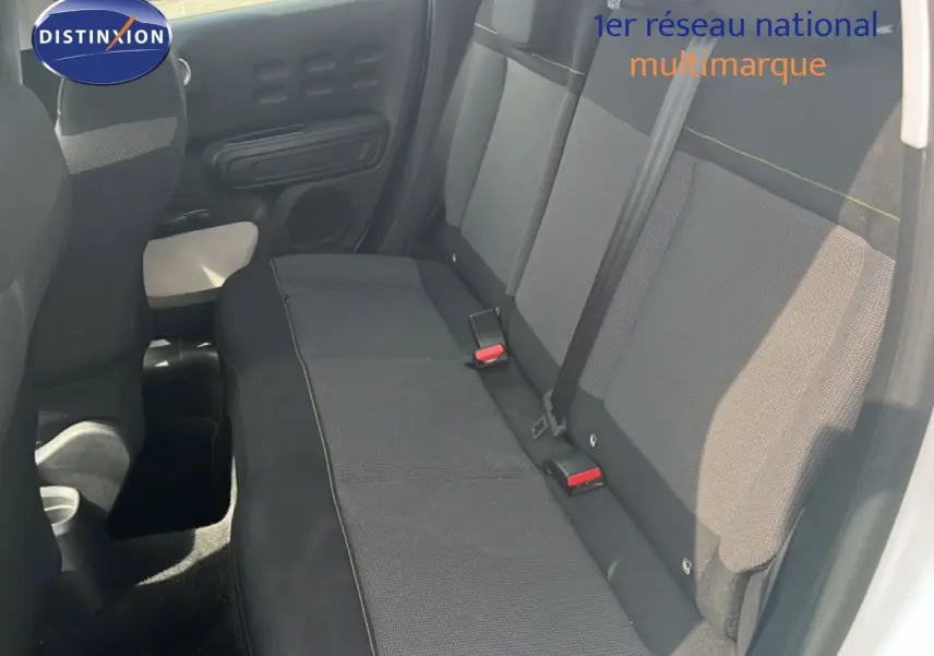 Vue intérieure côté droit montrant la banquette arrière en tissu gris foncé d'une Citroën C3 blanche de 2018.