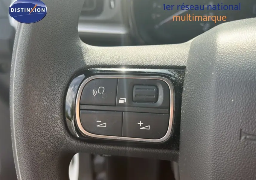 Gros plan sur les commandes vocales et volume au volant d'une Citroën C3 blanche essence de 2018.