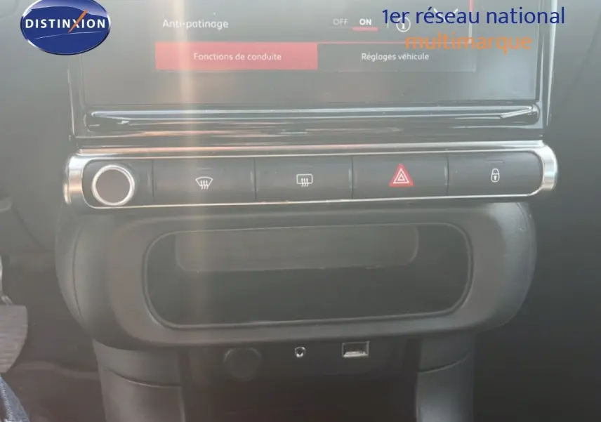 Vue rapprochée de la console centrale noire avec commandes de climatisation et écran tactile du Citroën C3 blanc 2018.