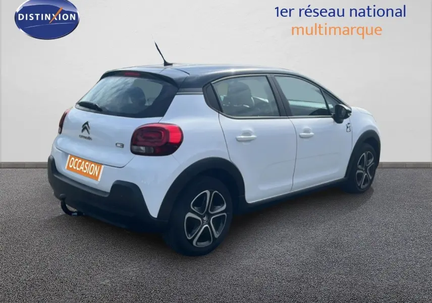 Citroën C3 blanc vue 3/4 arrière droit avec toit noir et jantes distinctives, en extérieur sur sol gris.