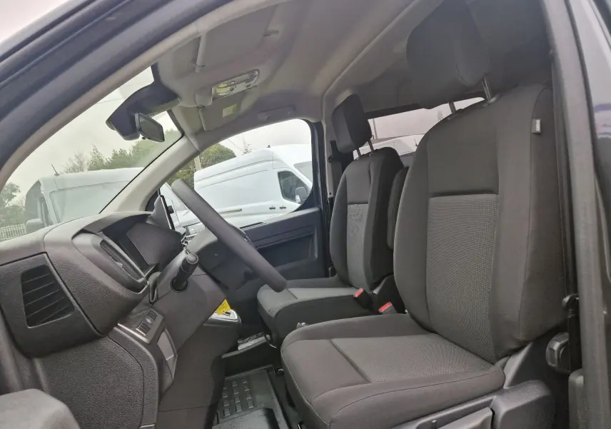 Vue intérieure côté gauche du poste de conduite du Citroën Jumpy Cabine Approfondie gris titane avec sièges noirs.