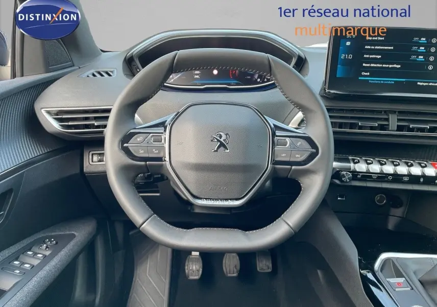 Vue intérieure centrée sur le volant Peugeot 3008 2023, tableau de bord moderne avec écran tactile et commandes intégrées.