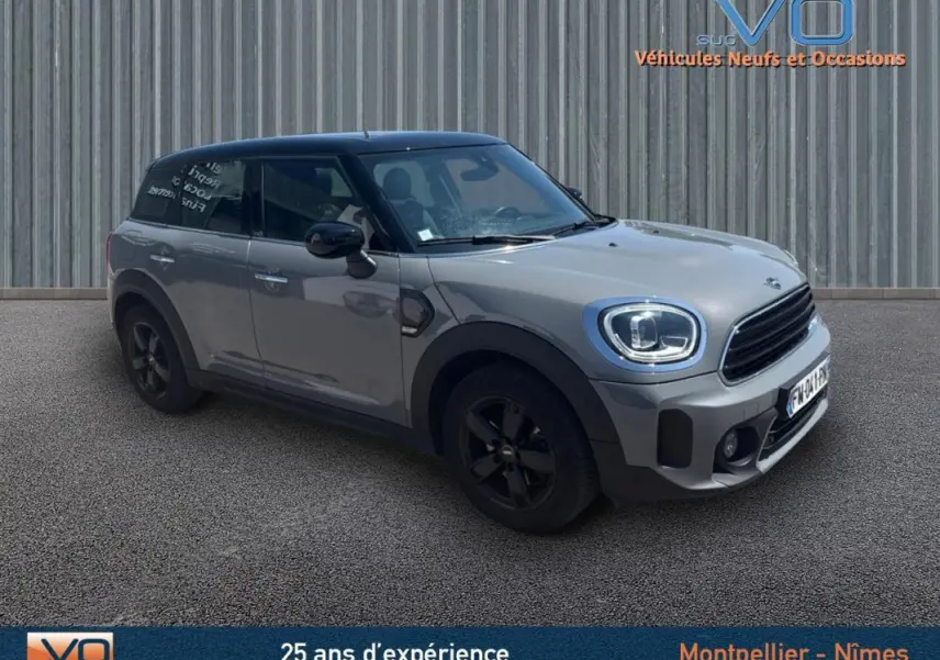 Vue 3/4 avant gauche d'une MINI Countryman gris clair avec toit noir et jantes alliage noires.