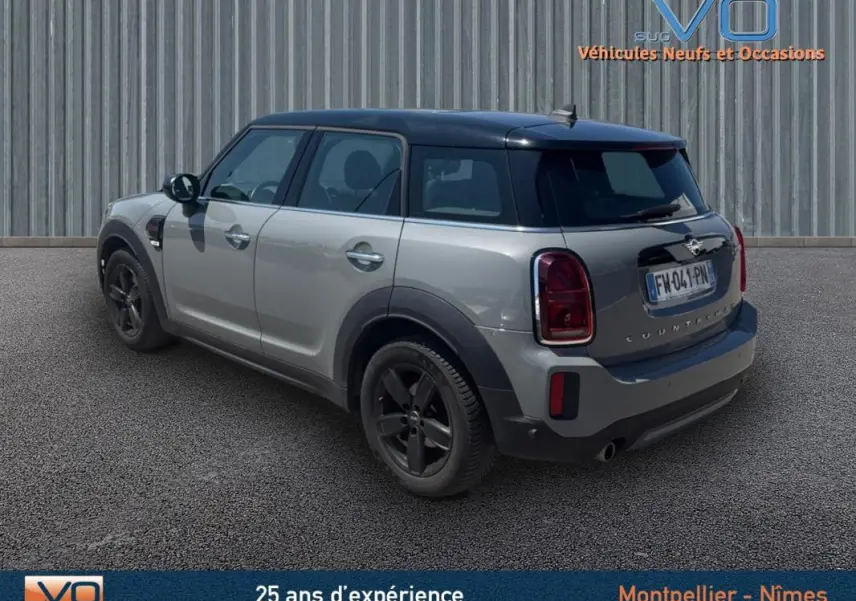 Vue 3/4 arrière droite d'une MINI Countryman gris clair avec toit noir et jantes alliage 17 pouces.