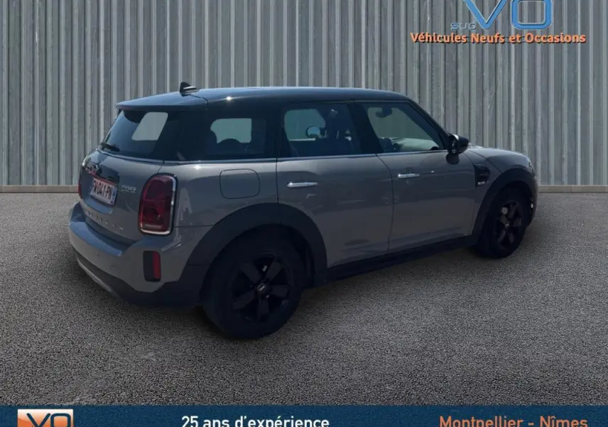 Vue 3/4 arrière droite d'une MINI Countryman gris clair avec toit noir et jantes alliage noires.