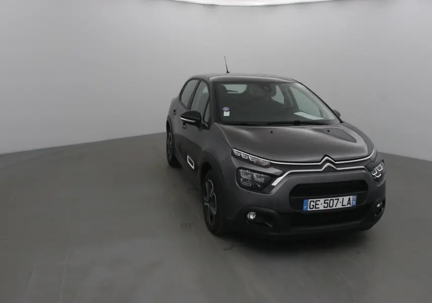 Citroën C3 gris platinium vue 3/4 avant droit dans un studio, avec signature lumineuse LED distinctive.