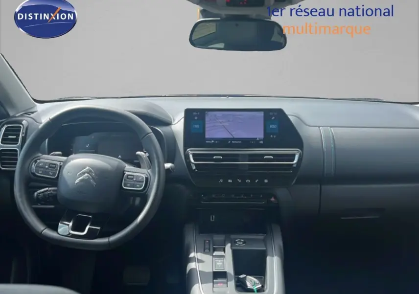Vue intérieure du tableau de bord et volant noir du Citroën C5 Aircross 2025 hybride avec écran tactile central.