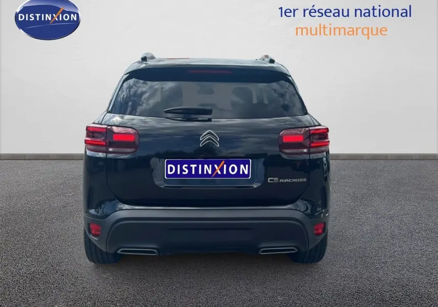 Vue arrière d'un Citroën C5 Aircross noir métal 2025 avec feux rouges allumés et logo distinctif visible.