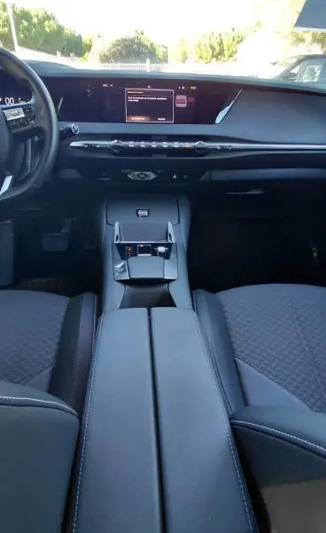 Vue intérieure avant du DS4 Hybride E-Tense 225 Bastille 2024, montrant la console centrale et le tableau de bord noir moderne.