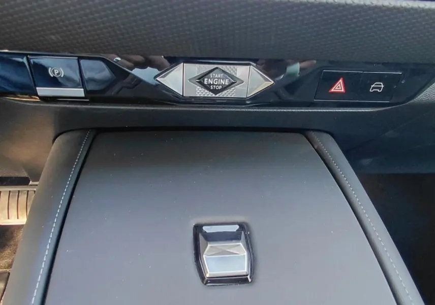 Vue rapprochée de la console centrale du DS4 2024 Hybride E-Tense avec bouton start engine et commandes noires brillantes.