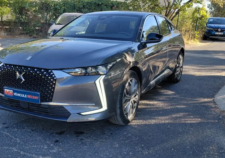 DS4 Hybride E-Tense 225 gris 2024 vue 3/4 avant droit, calandre distinctive avec logo DS et feux LED en forme de flèche.