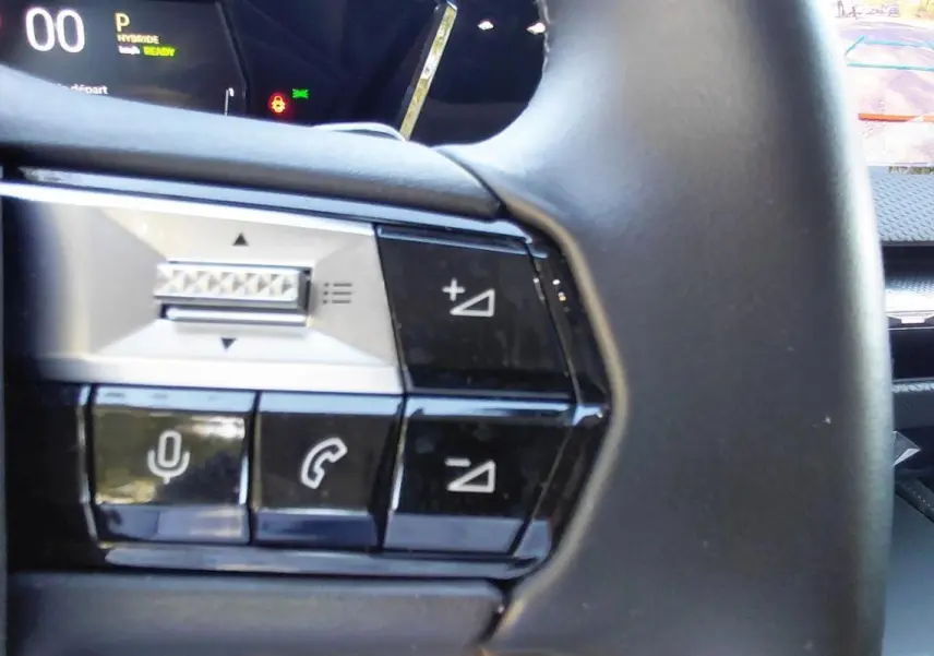 Gros plan sur les commandes au volant du DS4 gris 2024 Hybride E-Tense, avec écran numérique et caméra de recul visible.
