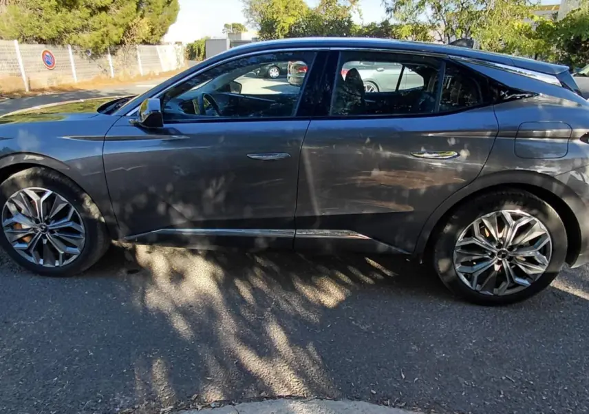 Vue de profil côté gauche d'une DS4 gris 2024 Hybride E-Tense avec jantes alliage et lignes sculptées distinctives.
