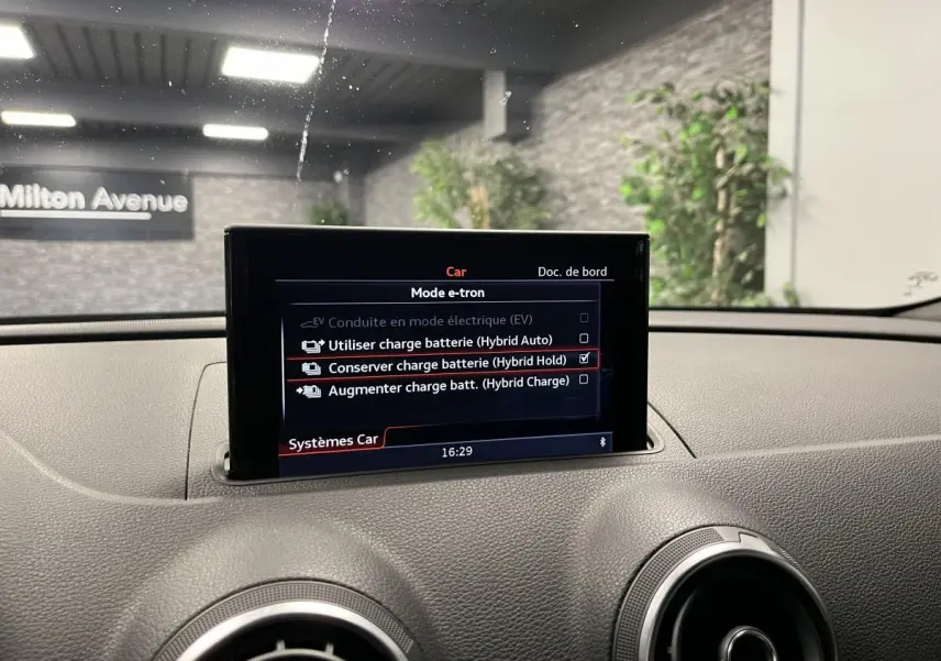 Écran central du tableau de bord d'une Audi A3 1.4 TFSI e-tron S line affichant les modes de charge batterie hybride.