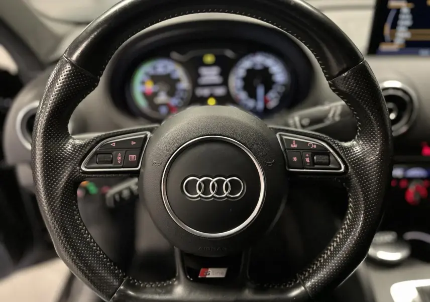 Volant sport en cuir perforé noir avec logo Audi et badge S line, intérieur de l'Audi A3 hybride rechargeable 2015.