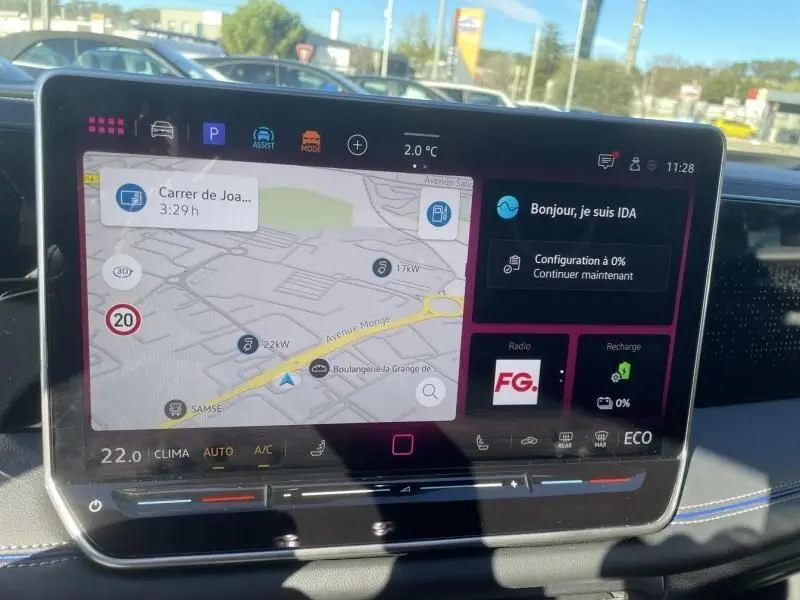 Vue intérieure sur l’écran tactile du tableau de bord du Volkswagen Tiguan 1.5 eHybrid gris métal, affichant la navigation et l’assistant IDA.