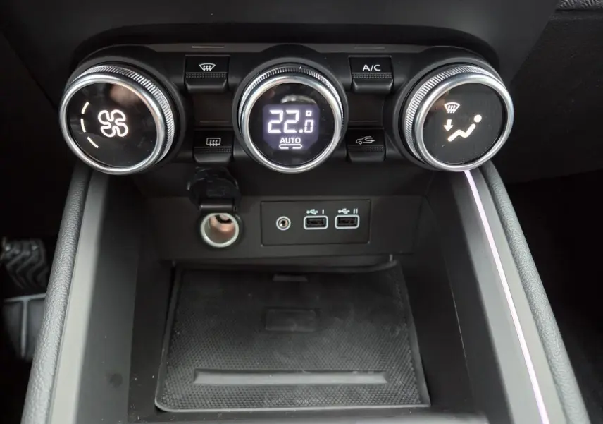 Vue rapprochée de la console centrale de la Renault Clio 2025 avec commandes de climatisation et ports USB.