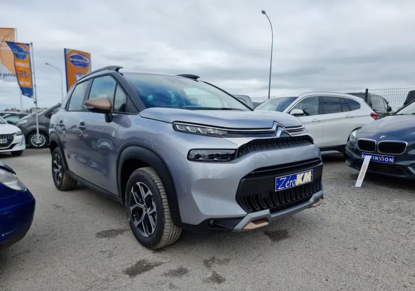 SUV Citroën C3 Aircross gris Artence en 3/4 avant droit avec coques de rétroviseurs bronze et jantes alliage diamantées.