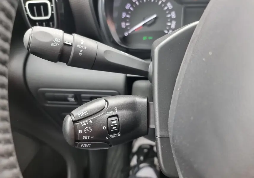 Gros plan sur les commandes de régulateur de vitesse et des phares du tableau de bord d'une Citroën C3 Aircross 2022.