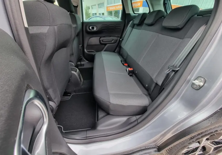 Vue intérieure côté arrière droit du Citroën C3 Aircross gris Artence, montrant la banquette arrière en tissu gris.