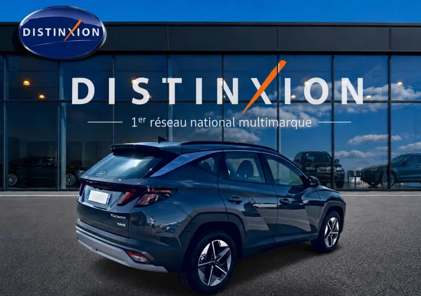 Vue 3/4 arrière droite du Hyundai Tucson gris ecotronic hybride, avec jantes alu et feux arrière LED visibles.