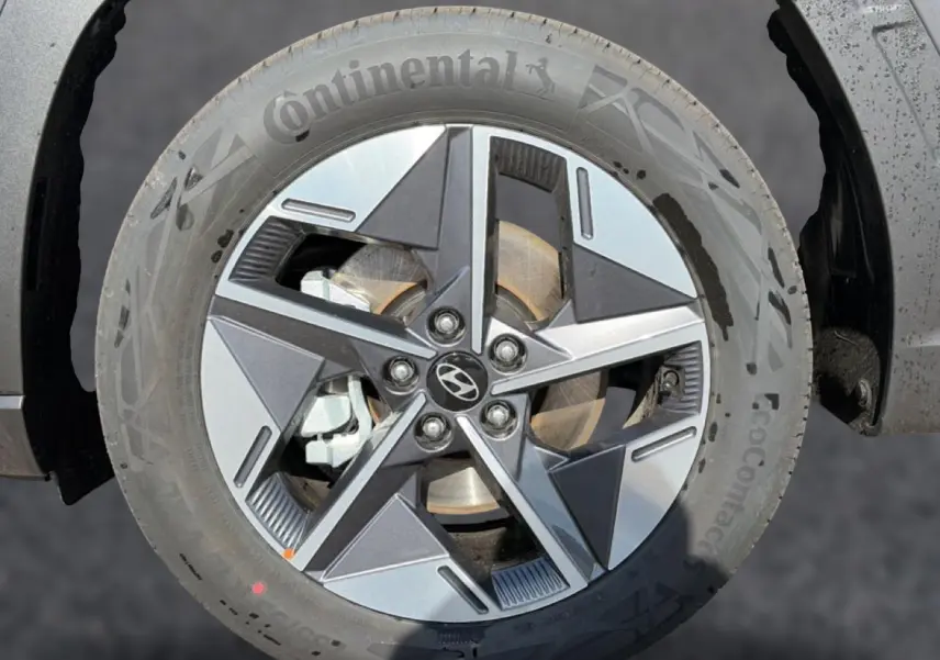 Gros plan sur la jante alu 18 pouces gris ecotronic du Hyundai Tucson 1.6 t-gdi 239 hybrid intuitive avec logo Hyundai central.