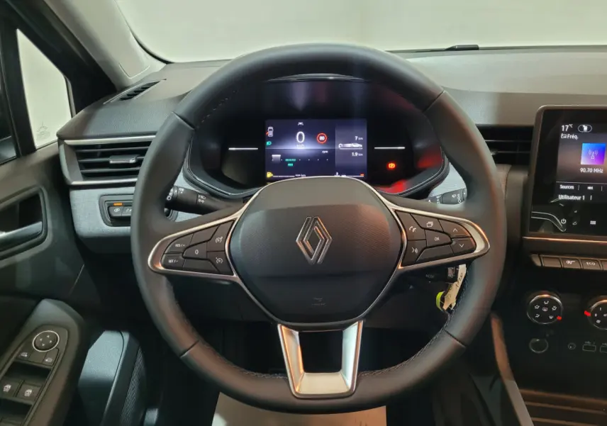 Vue centrée sur le volant cuir noir et le tableau de bord numérique de la Renault Clio gris foncé Evolution 2025.