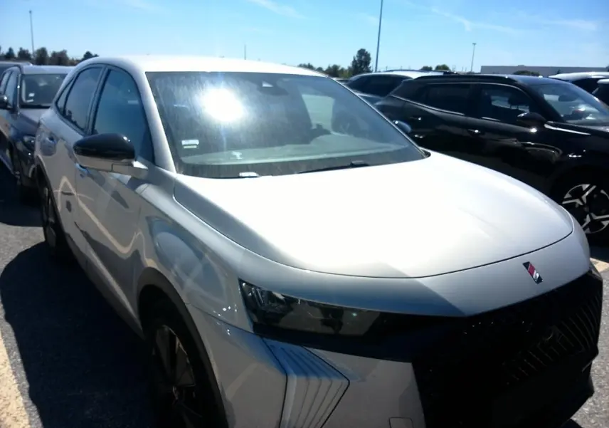 DS7 1.6 E-Tense 225 blanc Cristal Pearl en 3/4 avant gauche, avec calandre noire et jantes alliage 19 pouces.