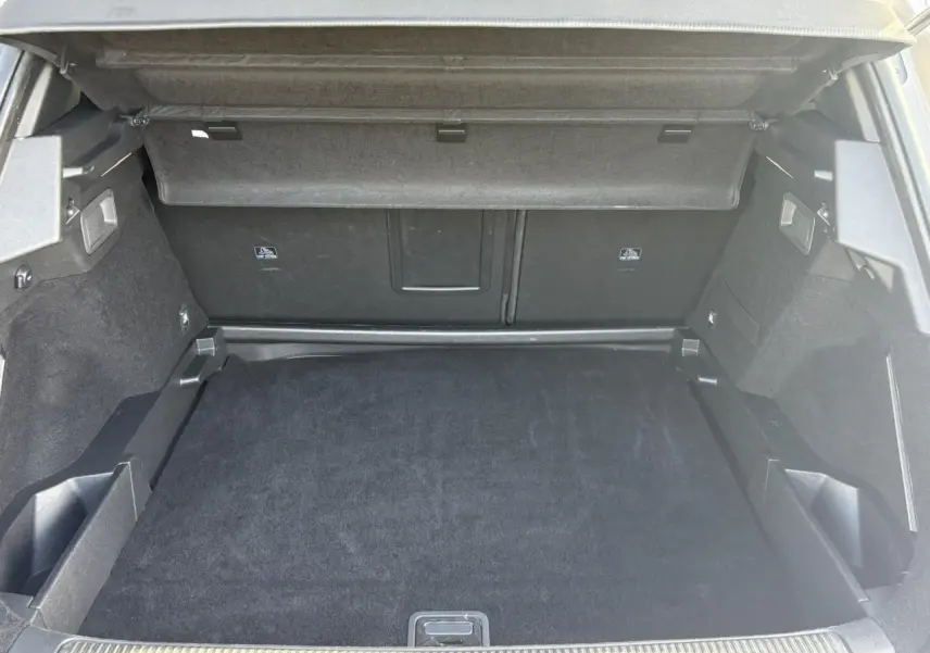 Coffre ouvert du DS7 1.6 E-Tense 225 en vue arrière, montrant un espace de chargement propre et bien fini.