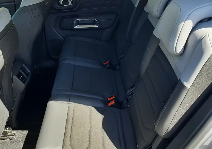 Vue intérieure côté droit des sièges arrière bi-ton gris clair et foncé du Citroën C5 Aircross Hybrid 2024, avec appuie-têtes et ceintures visibles.
