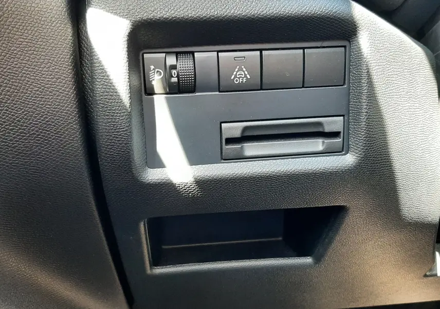Détail intérieur du tableau de bord côté gauche du Citroën C5 Aircross Hybrid 136 e-DCS6 Max, boutons de réglage et rangement noir.