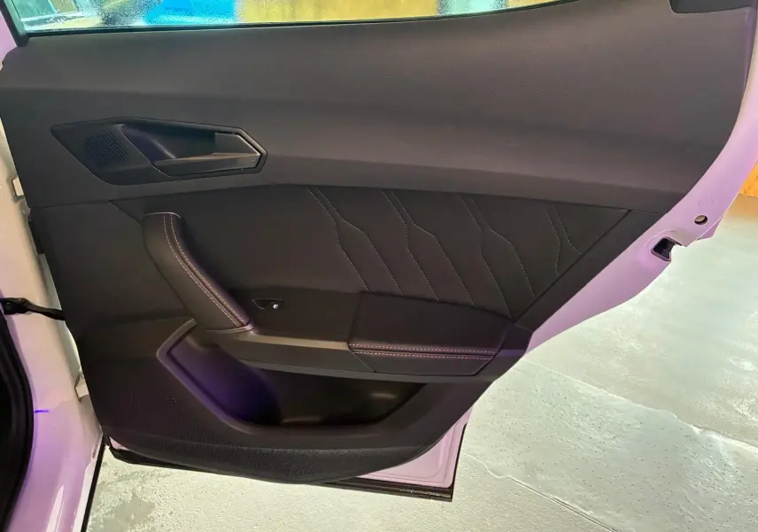 Gros plan sur la porte intérieure côté gauche de la CUPRA Formentor 1.4 E-HYBRID 2024 avec finition noire et surpiqûres.