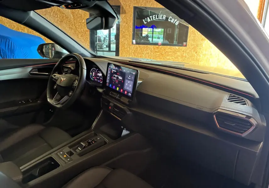 Vue intérieure côté conducteur du CUPRA Formentor gris 2024, mettant en valeur le tableau de bord numérique et l'écran tactile central.