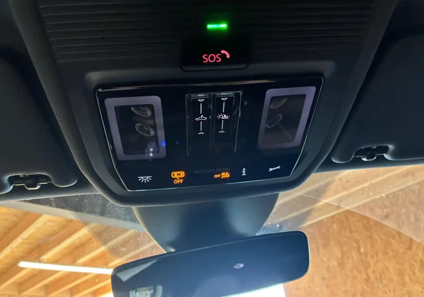 Vue en gros plan du panneau de commandes au plafond intérieur du CUPRA Formentor gris 2024, avec bouton SOS et voyants lumineux.