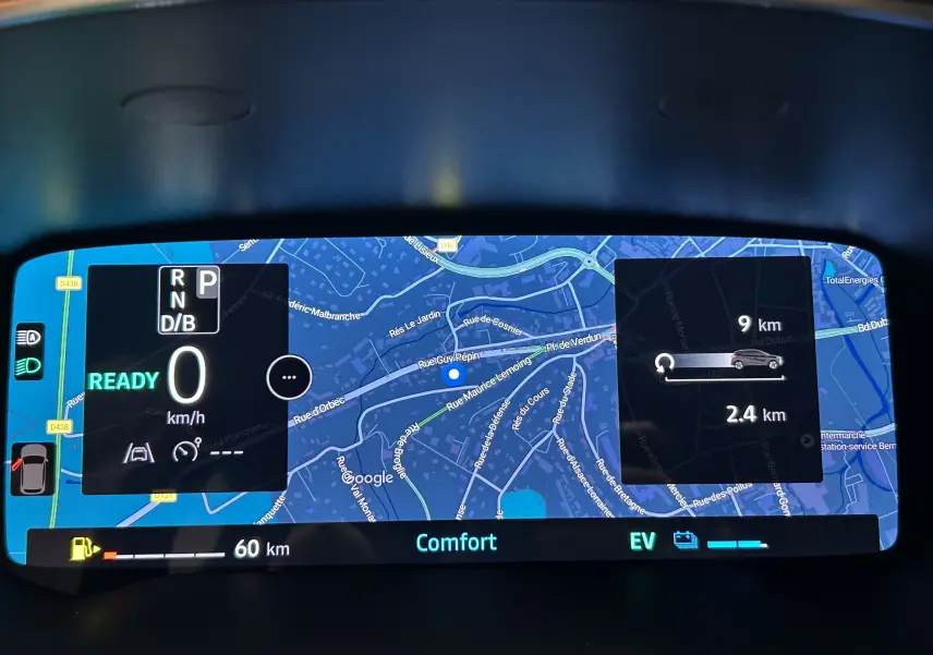 Tableau de bord numérique du Renault Captur blanc nacré, affichant la navigation et l'état hybride en mode confort.