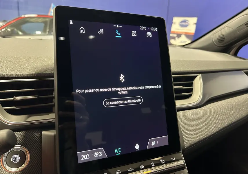 Vue intérieure du tableau de bord du Renault Captur blanc nacré 2026, écran tactile central avec interface Bluetooth.