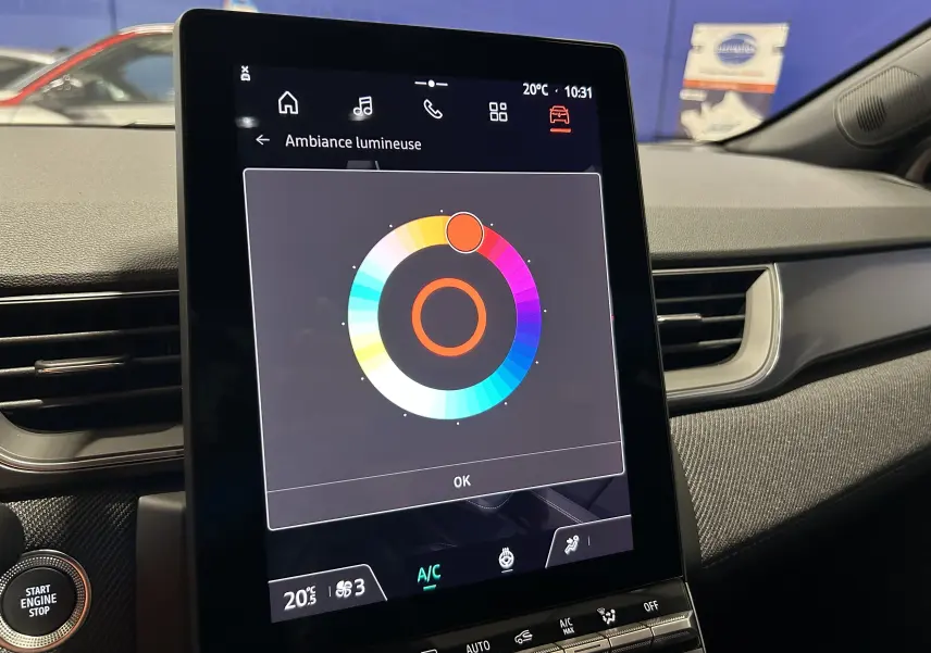 Vue intérieure centrée sur l'écran tactile du tableau de bord du Renault Captur blanc nacré, affichant la sélection d'ambiance lumineuse.