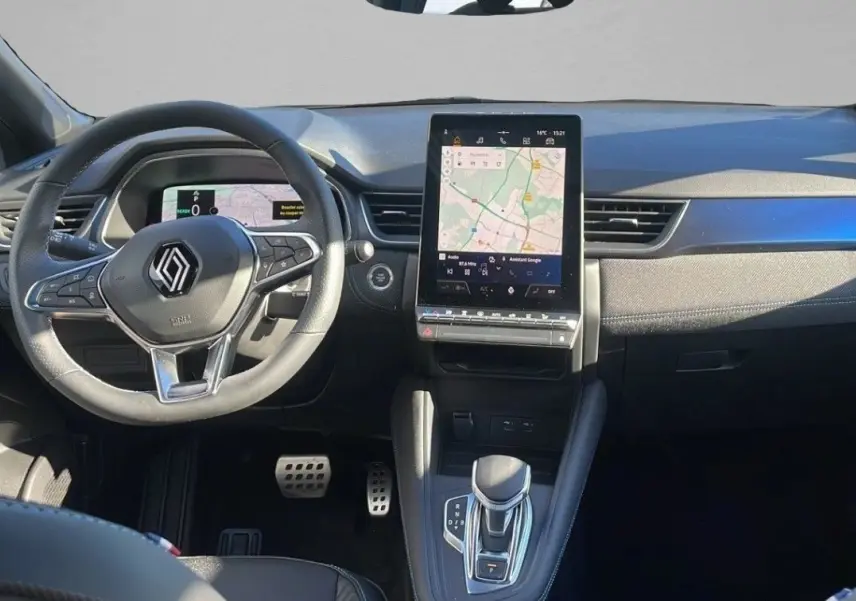 Vue intérieure frontale du tableau de bord du Renault Captur blanc nacré avec écran tactile vertical et volant multifonction.