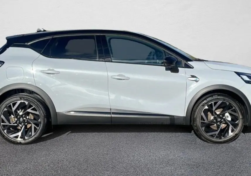 Renault Captur II Ph.2 blanc nacré en profil droit, avec toit noir et jantes alliage bi-ton distinctives.