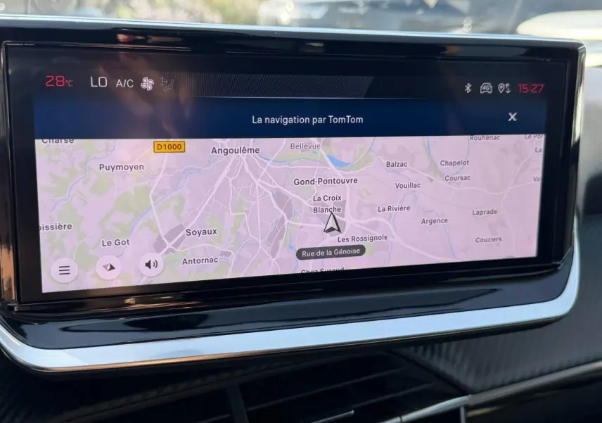 Écran tactile central de navigation TomTom dans l’habitacle d’une Peugeot 208 1.2 100ch gris Artense, vue rapprochée.