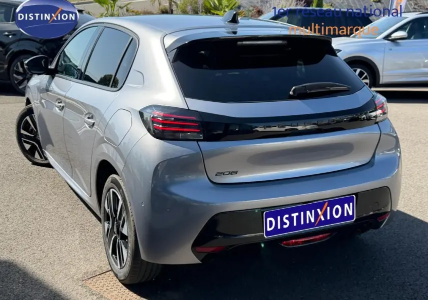 Vue 3/4 arrière droite d'une Peugeot 208 gris Artense avec feux arrière LED et vitres teintées sur parking extérieur.
