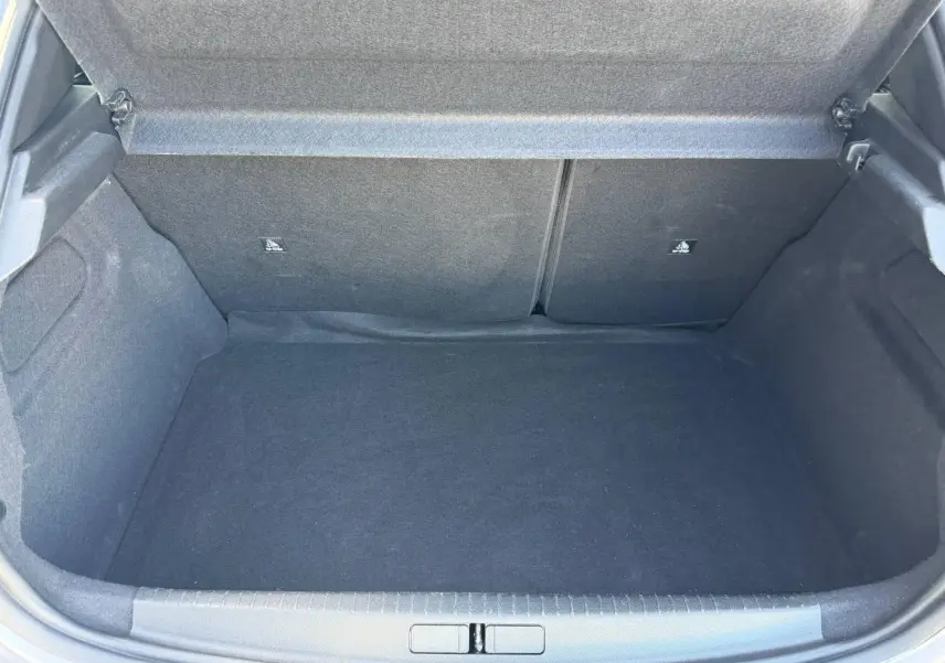 Coffre ouvert de la Peugeot 208 1.2 100ch gris Artense, montrant un espace de rangement propre et spacieux.