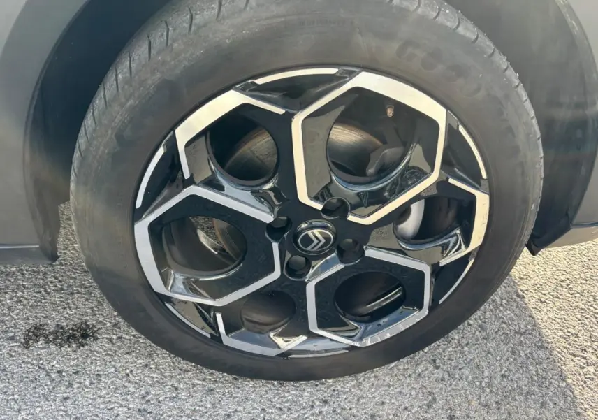 Gros plan sur la jante alliage noire et argentée de 17 pouces d'une Citroën C3 bleu 2025.