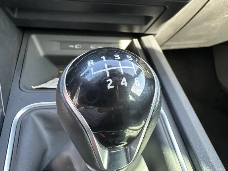 Gros plan sur le levier de vitesses manuel noir brillant du SEAT LEON ST 2.0 TDI 115ch STYLE XL 2025, détails des rapports visibles.