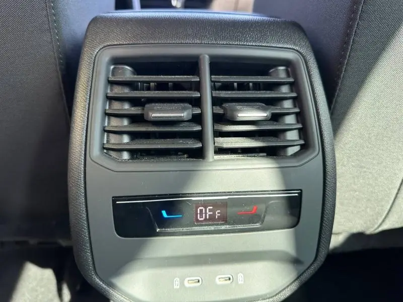 Vue rapprochée des aérateurs arrière et commandes de climatisation du SEAT LEON ST gris métallisé 2025.