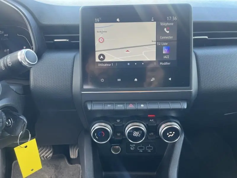 Tableau de bord de Renault Clio 1.6 E-Tech 140ch Business 2021 avec écran tactile GPS et commandes de climatisation rondes.