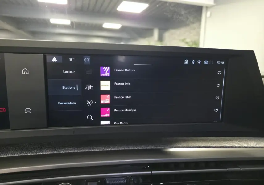 Écran tactile central du tableau de bord du Peugeot 3008 noir 2025 affichant les stations radio numériques.