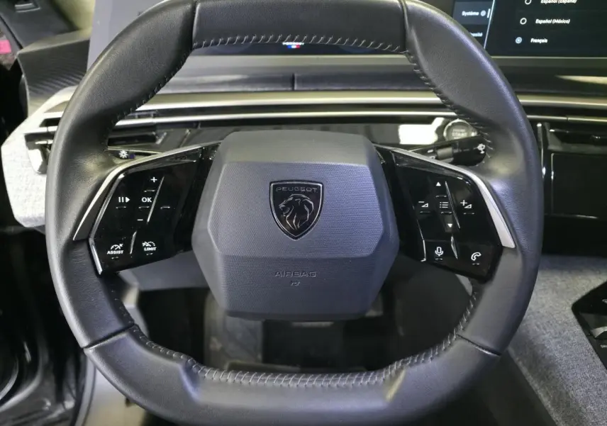 Volant compact noir de Peugeot 3008 2025 avec commandes tactiles intégrées et logo lion central.
