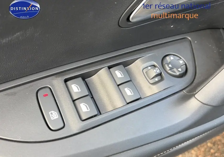 Gros plan sur les commandes de lève-vitres et réglage des rétroviseurs côté conducteur d'une Peugeot 2008 noire.